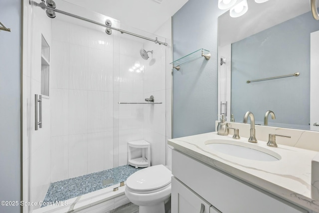 bathroom with vanity, toilet, and a stall shower