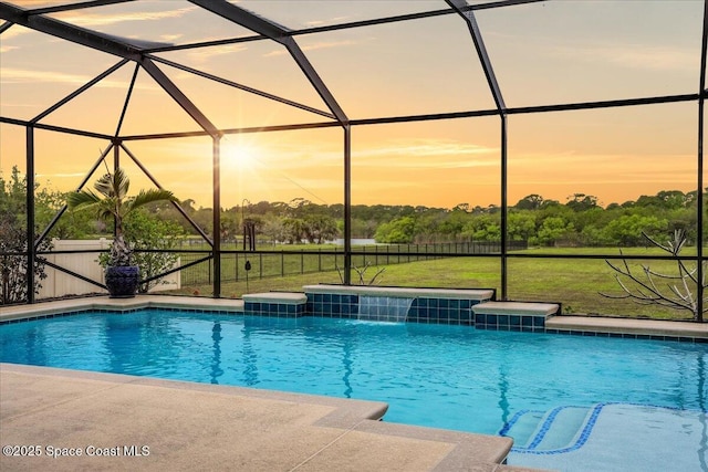 pool at dusk featuring an outdoor pool, a lawn, a lanai, and a patio area