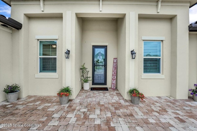 entrance to property featuring stucco siding