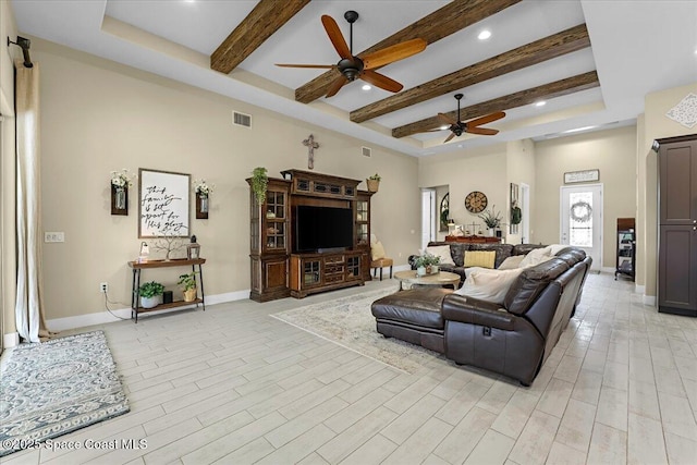 living room with baseboards, visible vents, light wood finished floors, beam ceiling, and ceiling fan