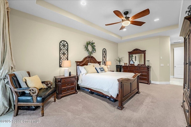 bedroom featuring baseboards, ceiling fan, light carpet, recessed lighting, and a raised ceiling