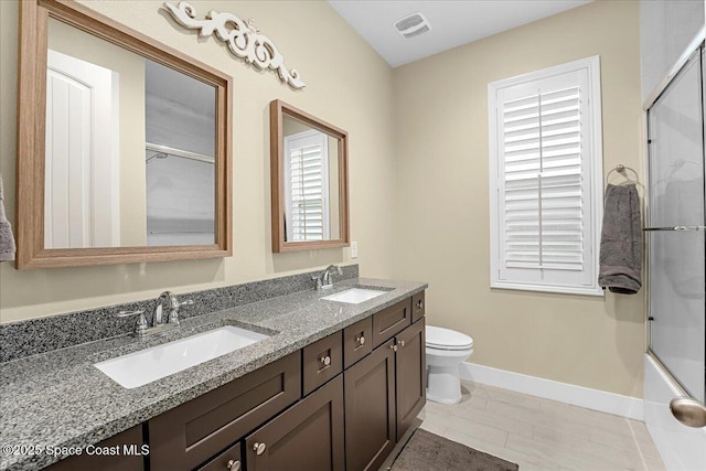 full bathroom with double vanity, toilet, visible vents, and a sink