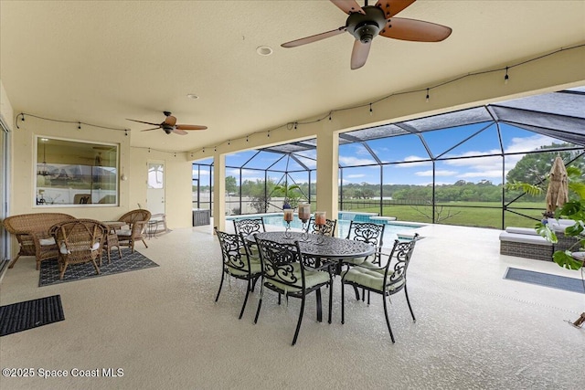 view of patio / terrace with an outdoor living space, outdoor dining space, glass enclosure, and a ceiling fan