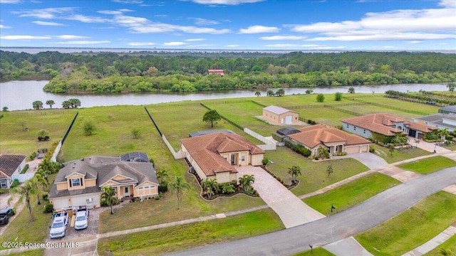 drone / aerial view featuring a residential view, a view of trees, and a water view