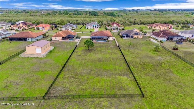 drone / aerial view featuring a residential view and a wooded view