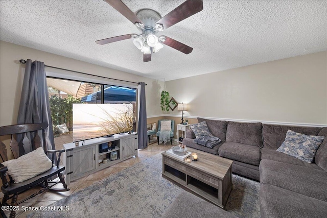 living room with tile patterned floors, a ceiling fan, and a textured ceiling