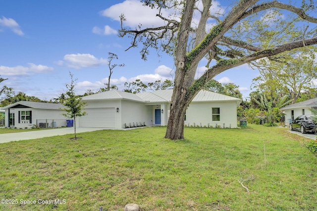 view of front of house featuring a front yard, an attached garage, stucco siding, concrete driveway, and metal roof