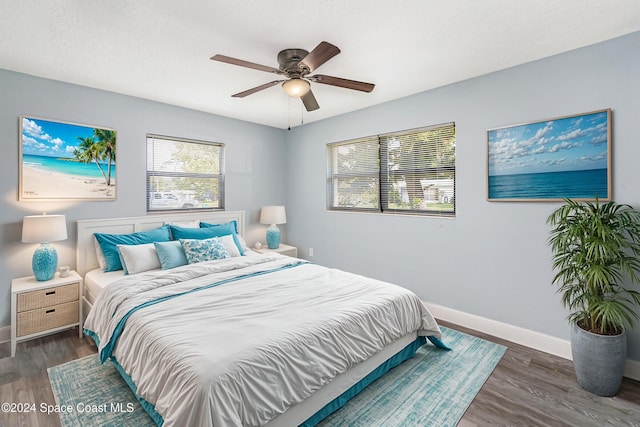 bedroom with baseboards, wood finished floors, and a ceiling fan