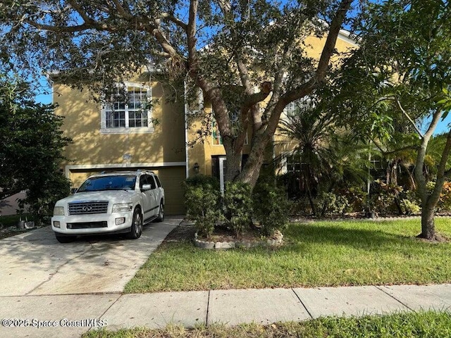 view of front of home with an attached garage, driveway, and stucco siding