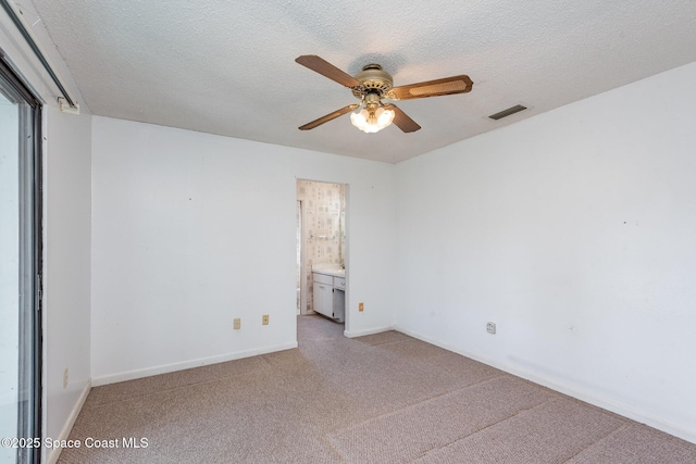 empty room featuring visible vents, carpet, ceiling fan, and a textured ceiling