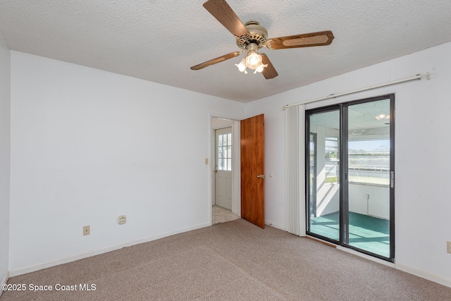 empty room featuring baseboards, carpet floors, a textured ceiling, and a ceiling fan