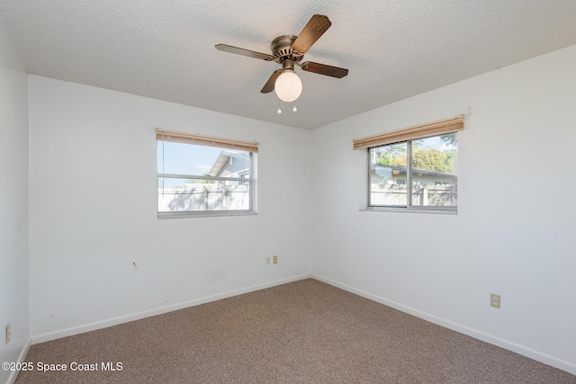 empty room with baseboards, carpet floors, and a textured ceiling