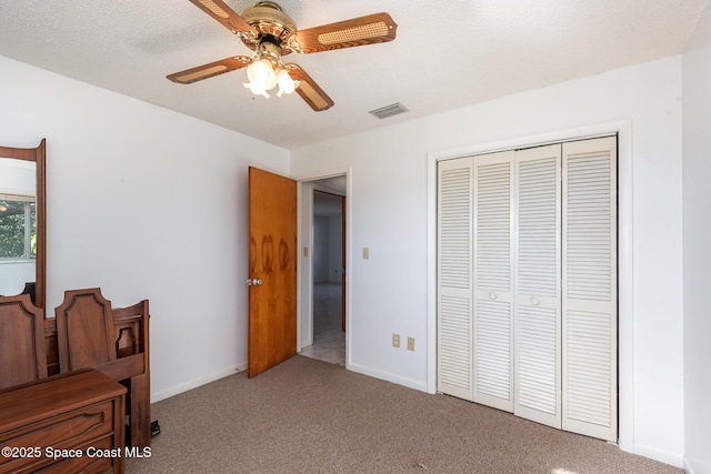 bedroom with visible vents, a textured ceiling, a closet, carpet, and baseboards