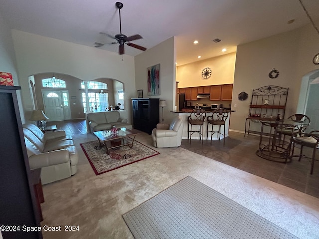 carpeted living area featuring visible vents, ceiling fan, recessed lighting, arched walkways, and high vaulted ceiling