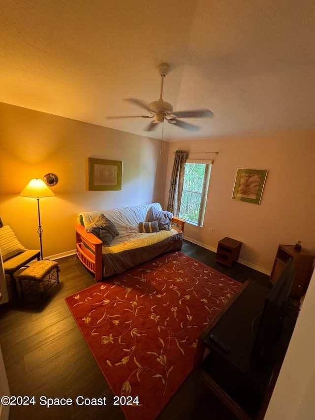 bedroom featuring baseboards, wood finished floors, and a ceiling fan