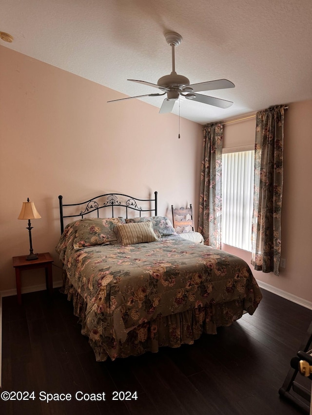 bedroom featuring ceiling fan, baseboards, and wood finished floors