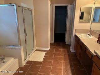 full bath featuring vanity, baseboards, tile patterned flooring, a shower stall, and a bath