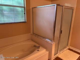 bathroom with tile patterned flooring, a stall shower, and a garden tub