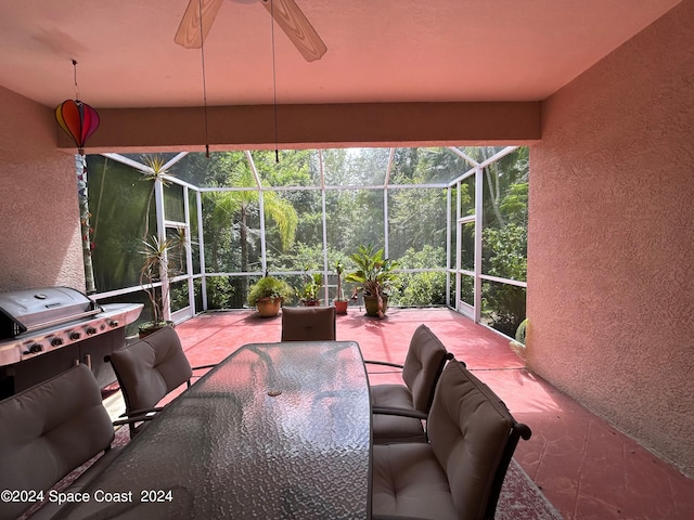 view of patio / terrace with glass enclosure, outdoor dining space, and grilling area