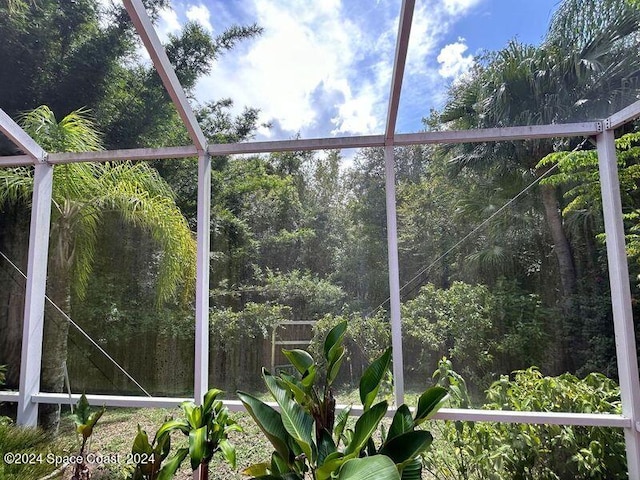 unfurnished sunroom with a wooded view