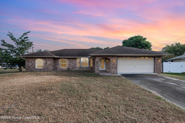 single story home with fence, a lawn, a garage, driveway, and a gate