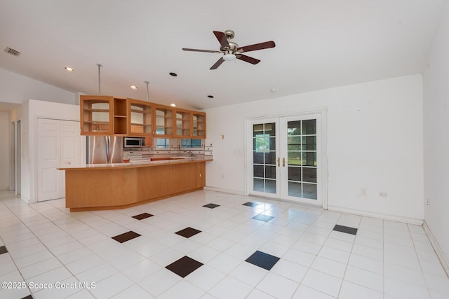 kitchen with visible vents, stainless steel appliances, french doors, a peninsula, and glass insert cabinets