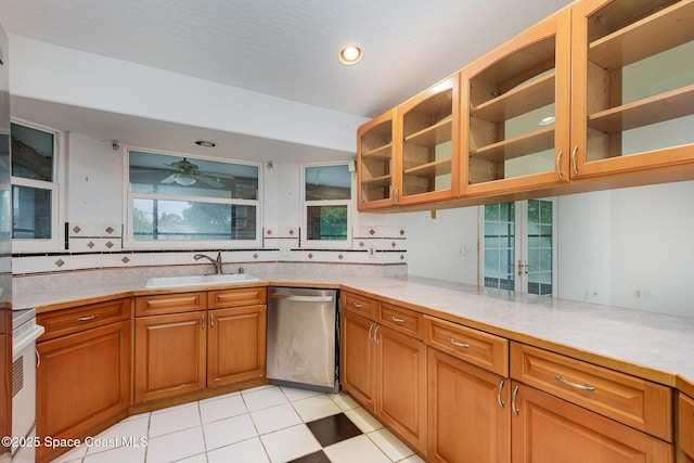 kitchen featuring stove, a sink, light countertops, and stainless steel dishwasher