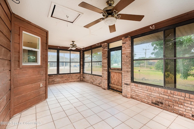 unfurnished sunroom featuring a ceiling fan