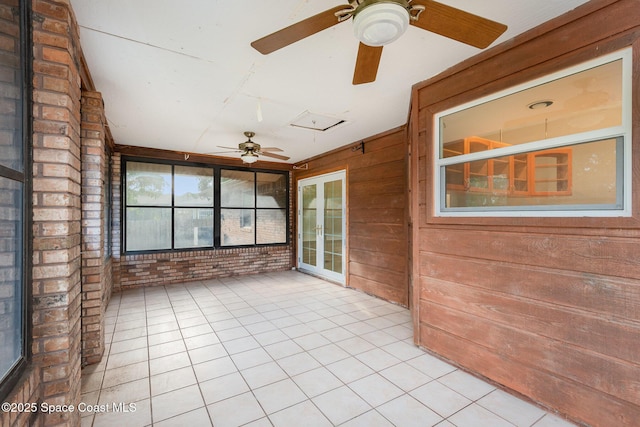 unfurnished sunroom featuring a ceiling fan