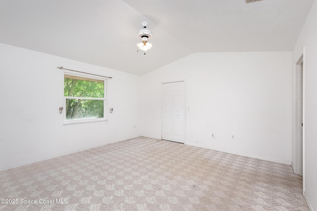 unfurnished room with carpet flooring and lofted ceiling