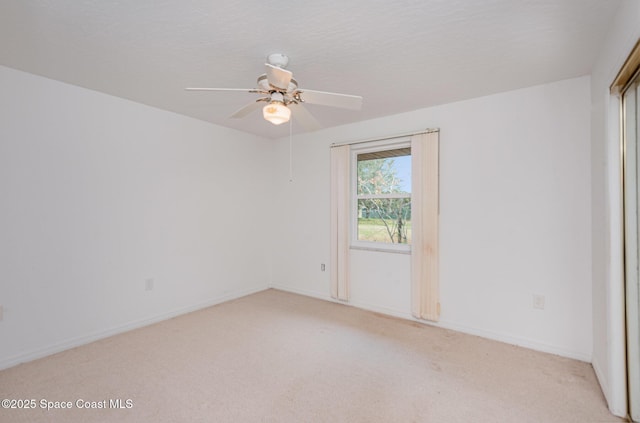 unfurnished room with a ceiling fan, light colored carpet, and baseboards