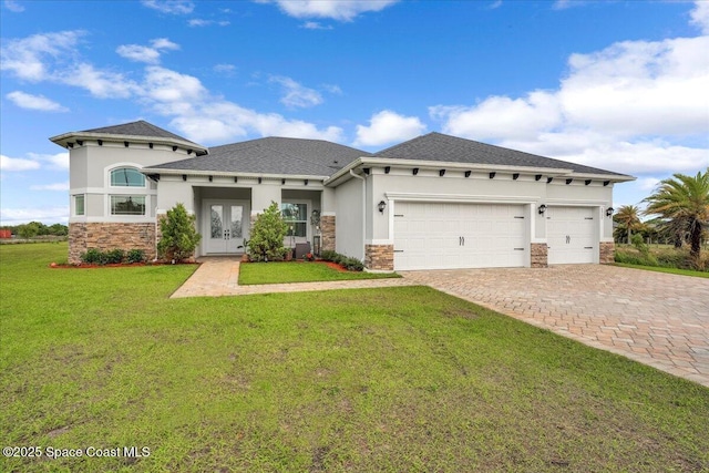 prairie-style home featuring a front yard, stucco siding, french doors, a garage, and decorative driveway