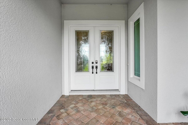 doorway to property featuring french doors and stucco siding