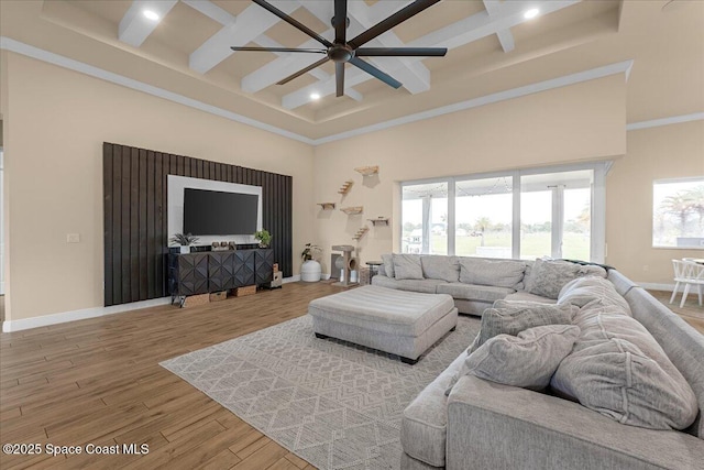 living area featuring baseboards, coffered ceiling, wood finished floors, and a ceiling fan