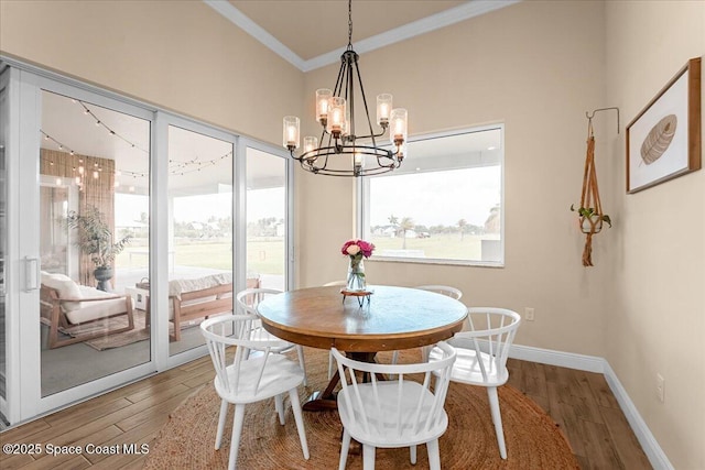 dining area featuring ornamental molding, baseboards, an inviting chandelier, and wood finished floors