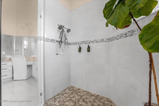 full bath featuring vanity and tiled shower