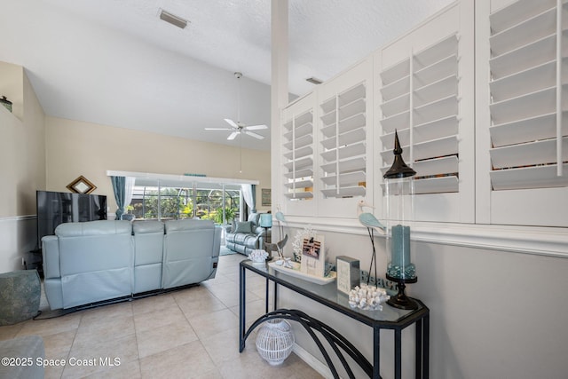 tiled living area featuring visible vents, a textured ceiling, lofted ceiling, and ceiling fan