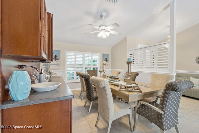 dining room featuring lofted ceiling, a textured ceiling, and ceiling fan