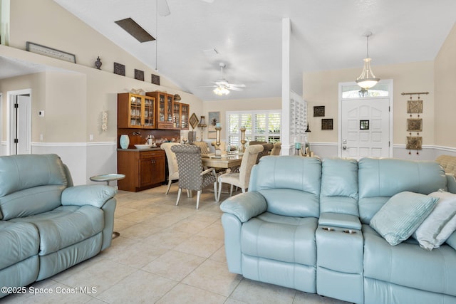 living room featuring vaulted ceiling, light tile patterned floors, and ceiling fan