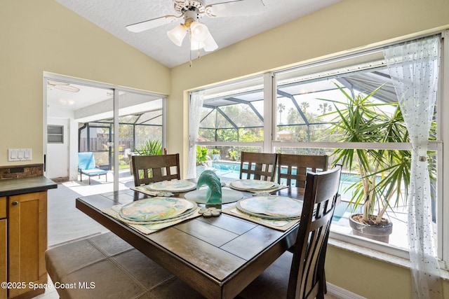 dining area featuring a textured ceiling, lofted ceiling, a ceiling fan, and a sunroom