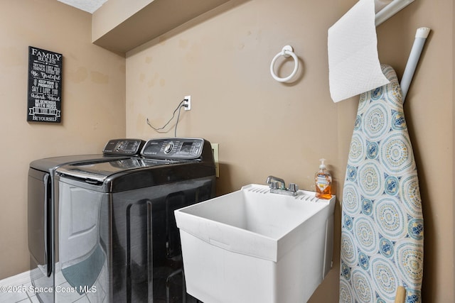 laundry area with laundry area, washer and dryer, and a sink