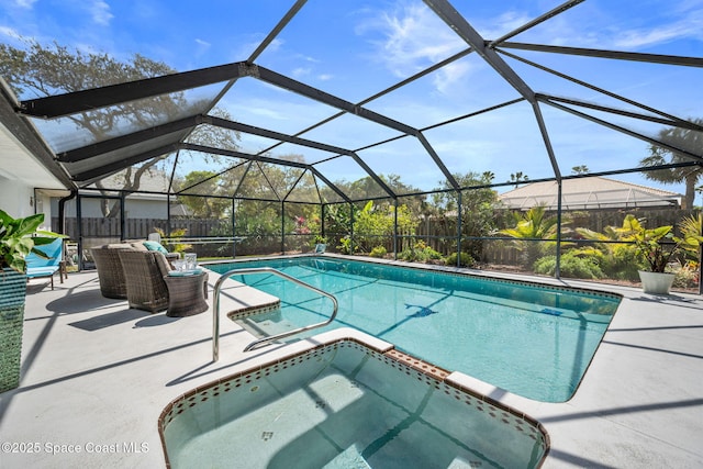 view of swimming pool featuring a lanai, a patio, a fenced backyard, and a pool with connected hot tub