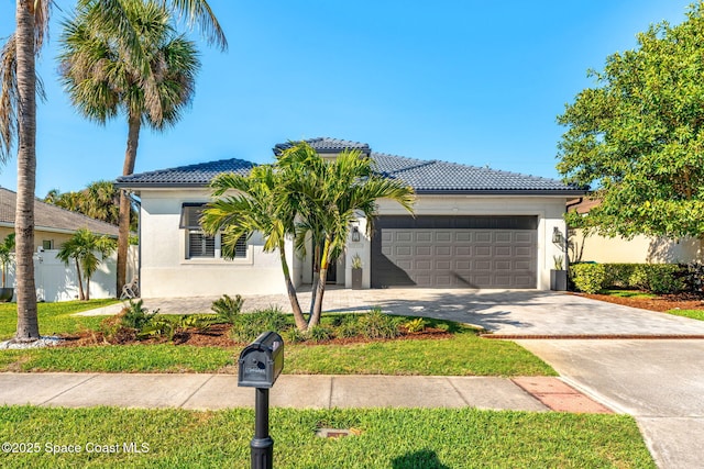 ranch-style house featuring a tiled roof, stucco siding, driveway, and a garage