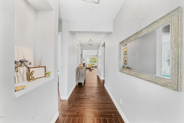 hall with a healthy amount of sunlight, baseboards, and wood tiled floor