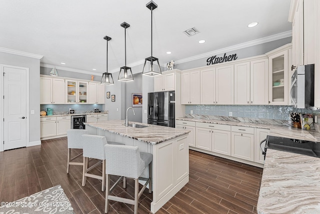 kitchen with beverage cooler, visible vents, a sink, stainless steel microwave, and refrigerator with ice dispenser