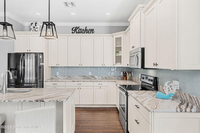 kitchen with visible vents, wood tiled floor, ornamental molding, appliances with stainless steel finishes, and a sink