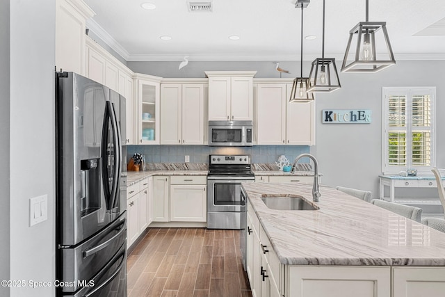 kitchen featuring a sink, backsplash, appliances with stainless steel finishes, and crown molding