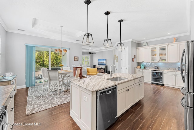 kitchen featuring a sink, wine cooler, appliances with stainless steel finishes, decorative backsplash, and wood tiled floor