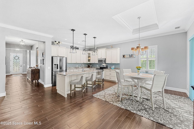 dining room with baseboards, a notable chandelier, dark wood-style floors, and ornamental molding