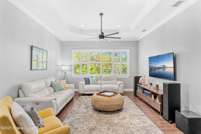 living room with visible vents, crown molding, wood finished floors, a raised ceiling, and a ceiling fan